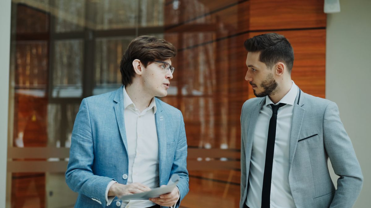 Two male executives discussing business in a modern office